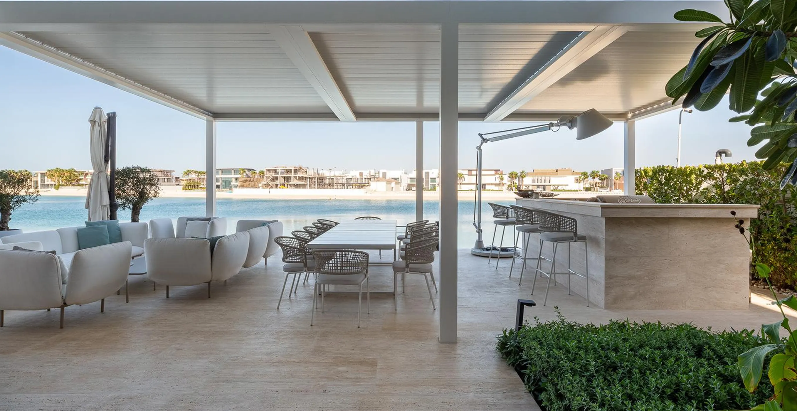 Luxurious outdoor dining and lounge area under a pergola in a luxury villa in Palm Jumeirah.