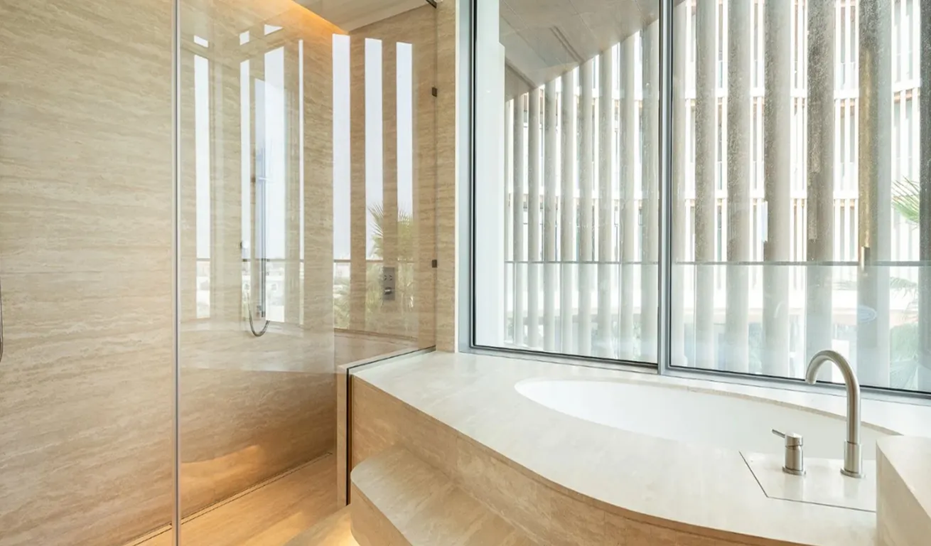 Modern villa bathroom interior fit-out with bathtub and expansive window in Palm Jumeirah.