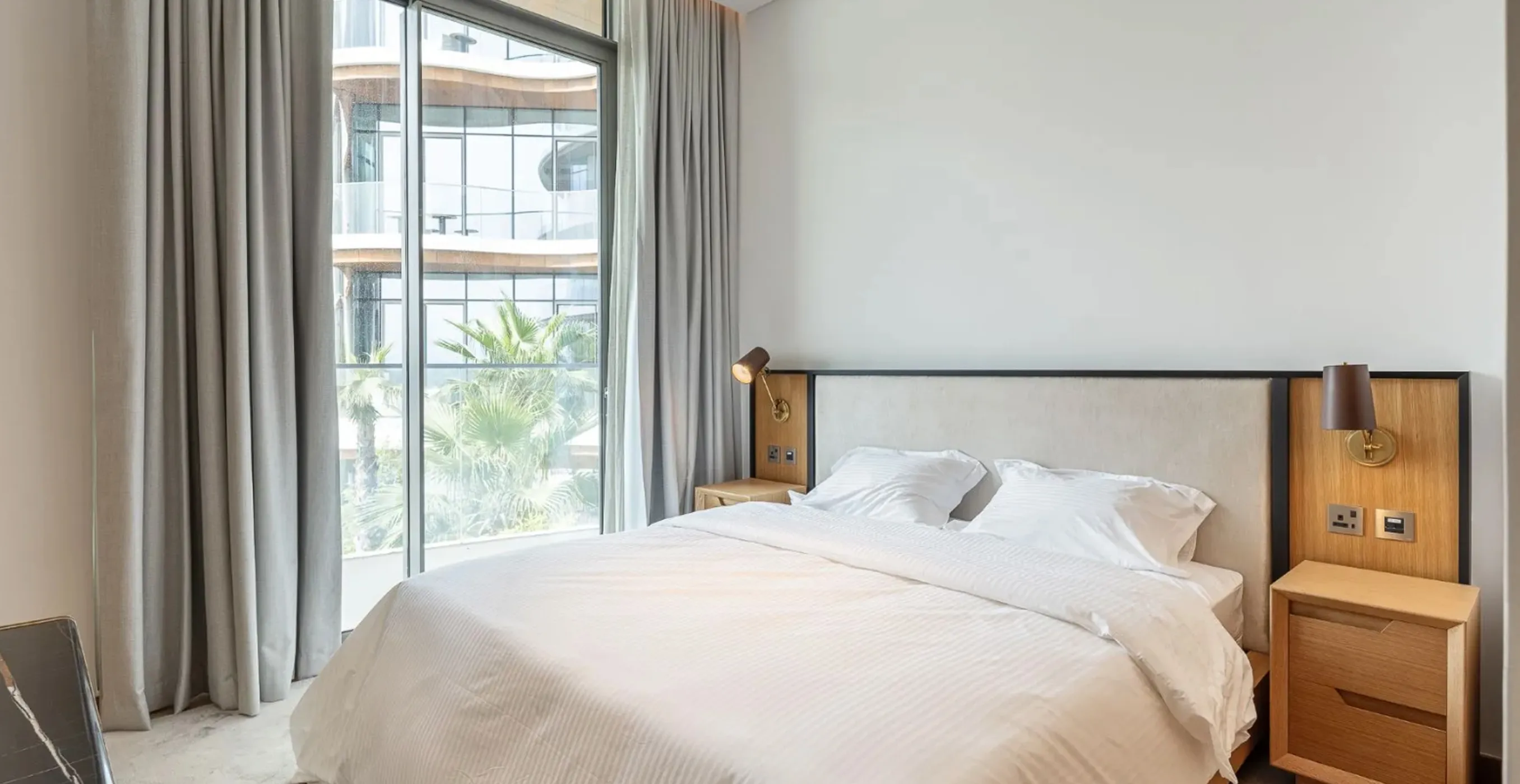 Luxury bedroom interior fit-out in Palm Jumeirah featuring floor-to-ceiling windows and minimalist decor.