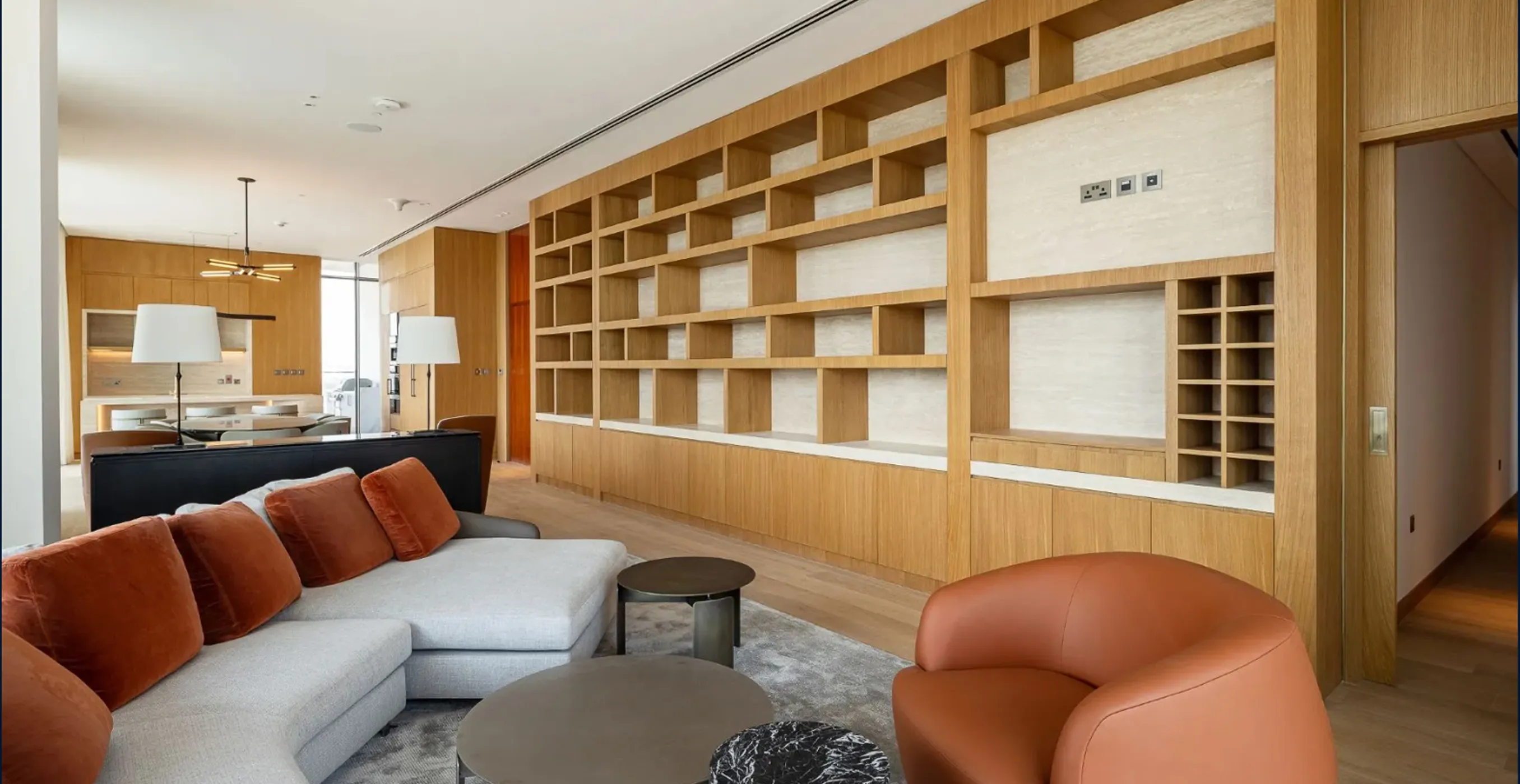 Modern villa living room interior fit-out with wooden bookshelf wall and custom-designed seating.