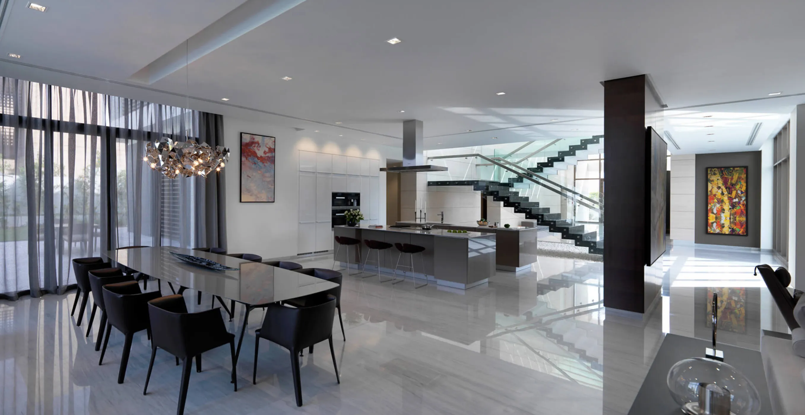 Modern open-concept interior fit-out featuring kitchen island and glass staircase.