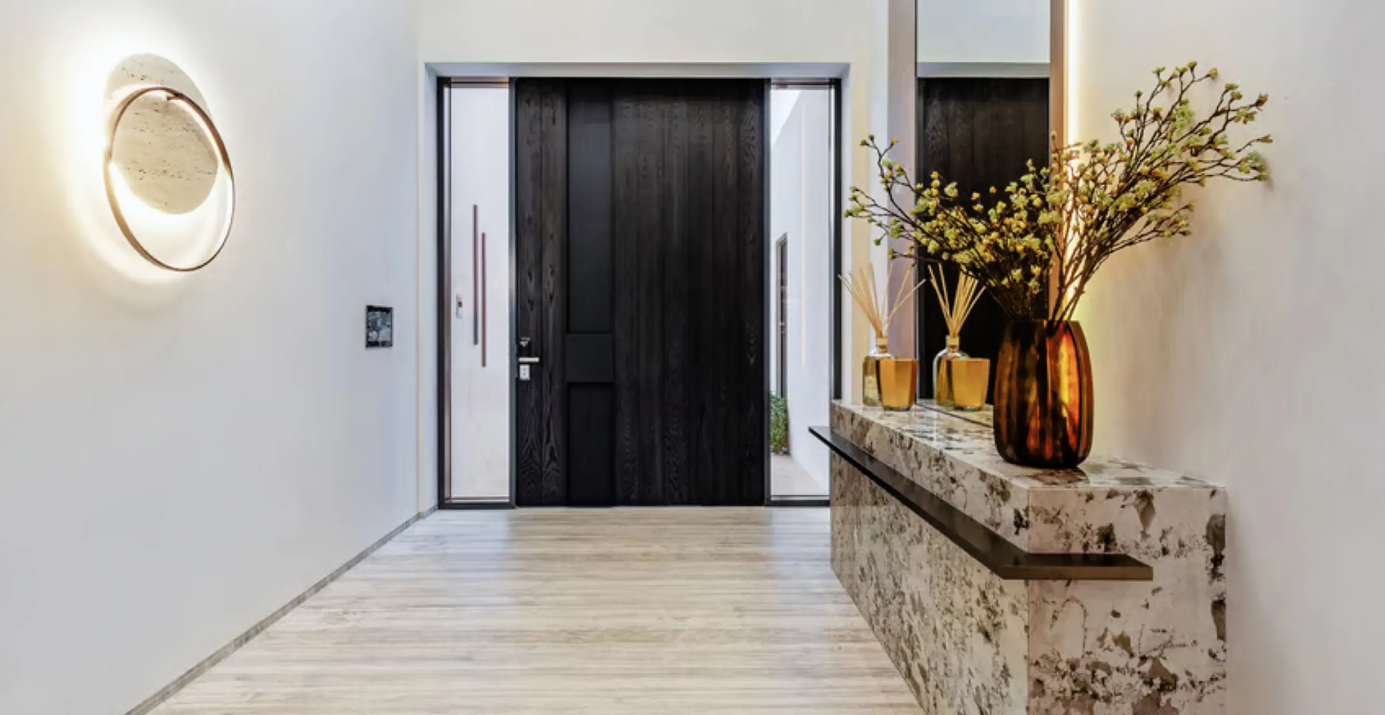 Modern hallway interior fit-out featuring a pivot door and wood flooring in a Signature Palm Villa.