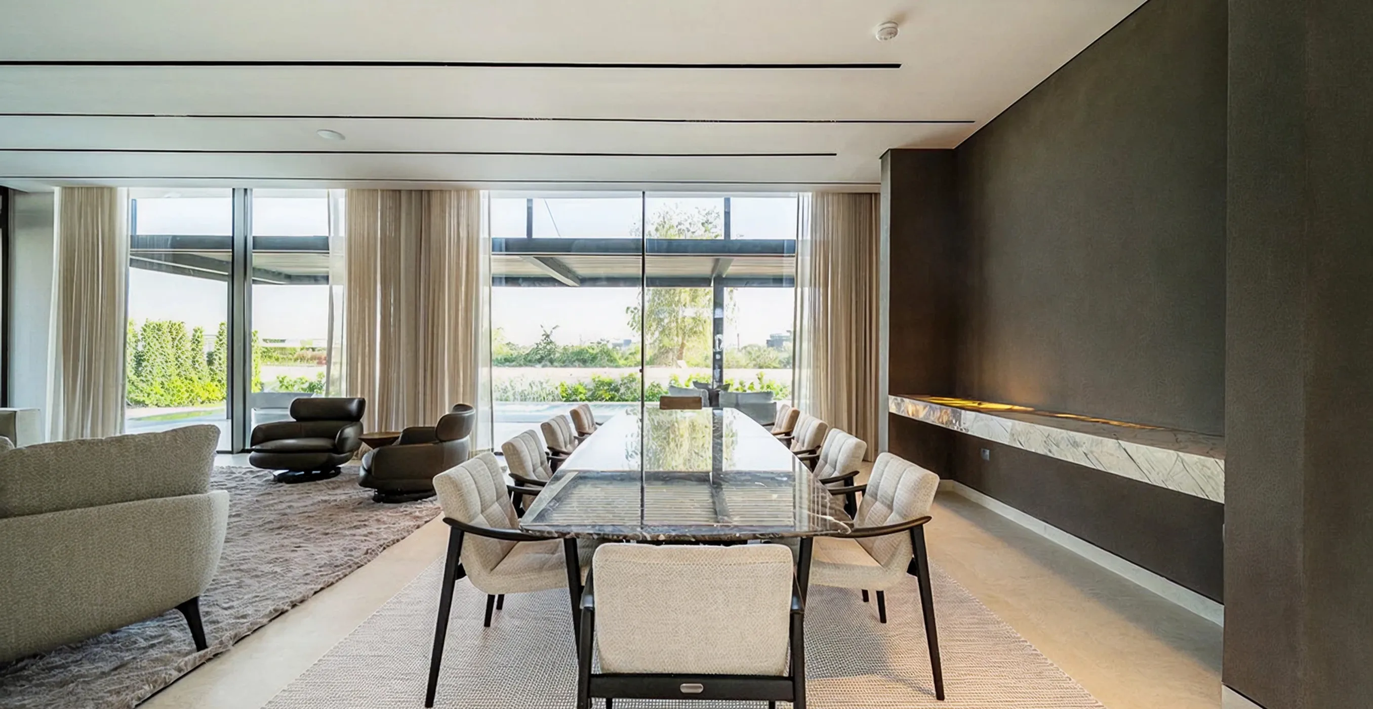 Luxurious open-plan interior design with marble dining table and floor-to-ceiling windows.