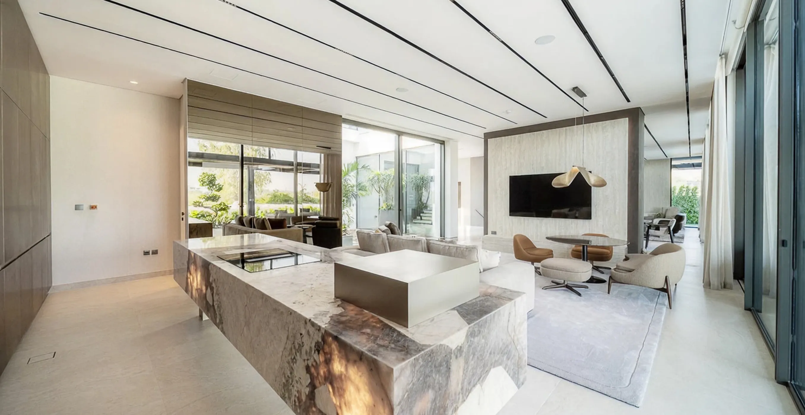 Modern villa interior fit-out featuring open kitchen, modern furnishings, and expansive windows.