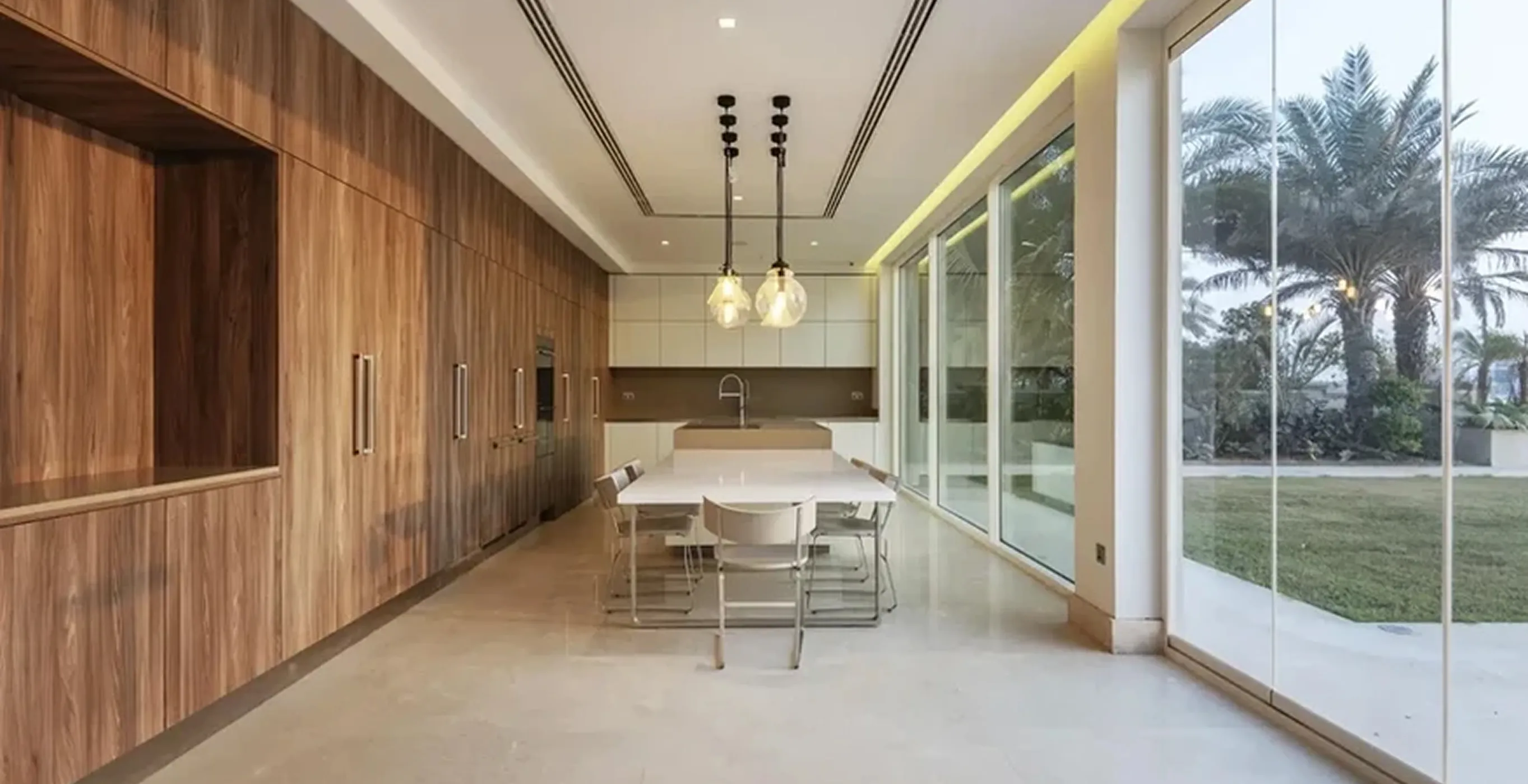 Modern kitchen interior fit-out with large island, floor-to-ceiling windows, and waterfront view in Dubai.
