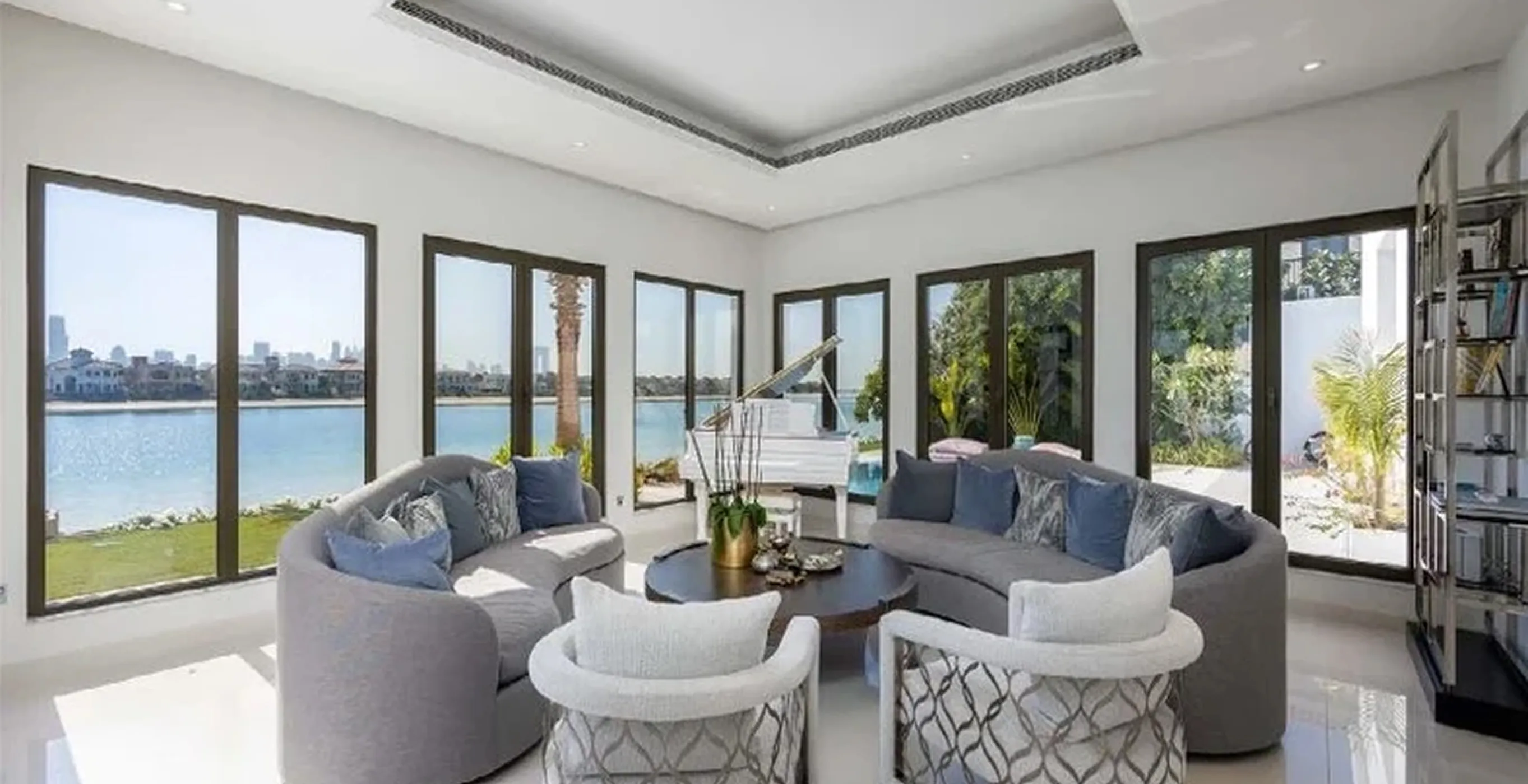 Luxury living room interior fit-out featuring modular sofas and expansive windows in a private villa.