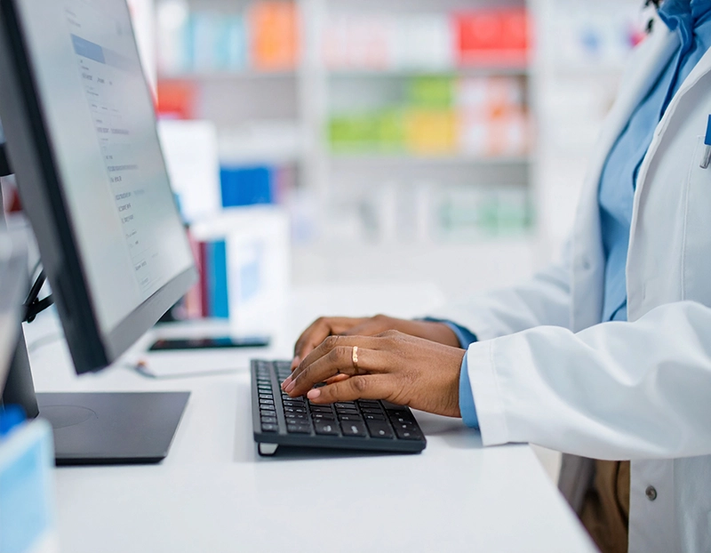 pharmacist typing on computer keyboard