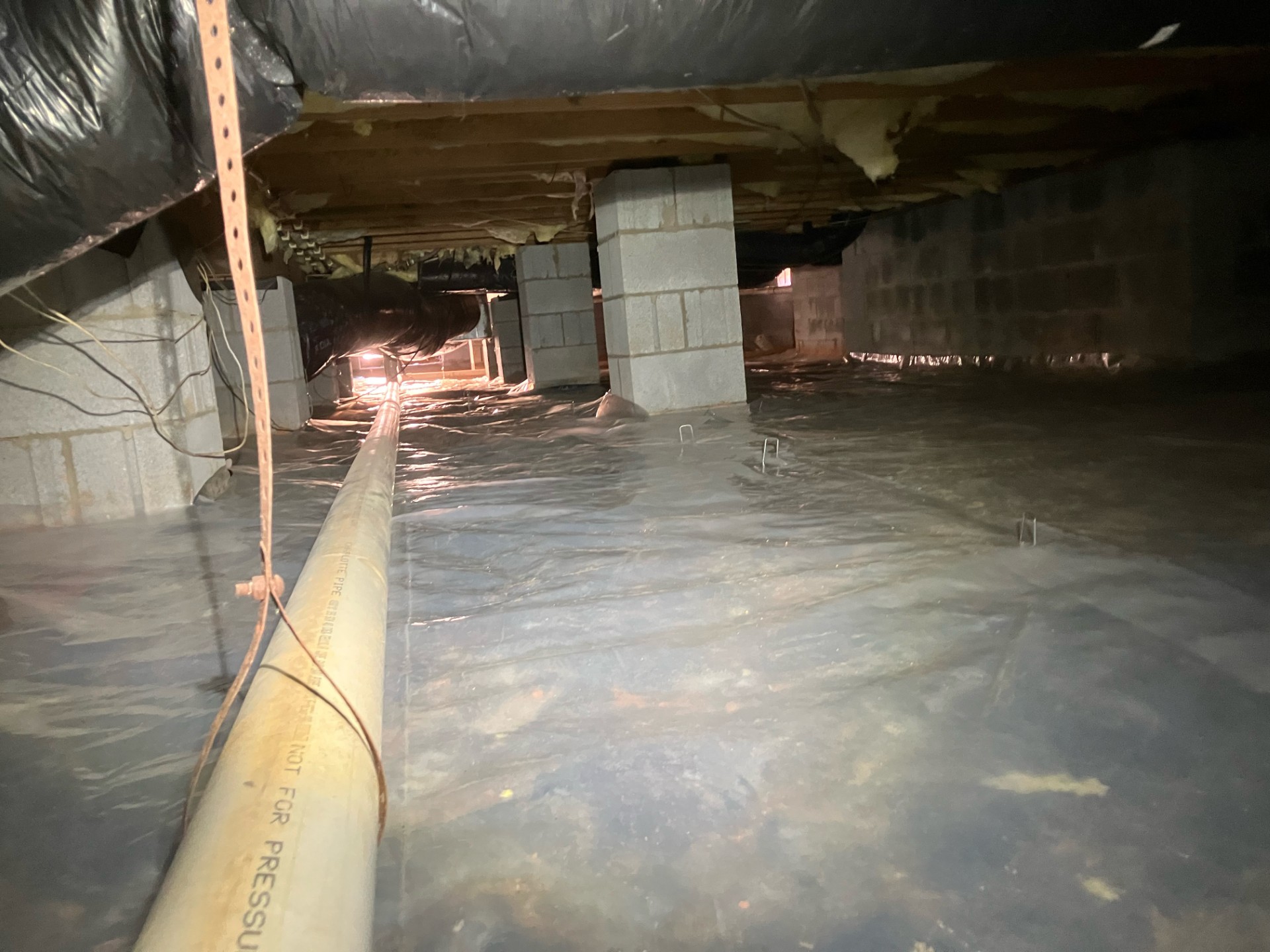 A polyethylene vapor barrier installed across a crawlspace floor to block ground moisture from rising into the home's structure
