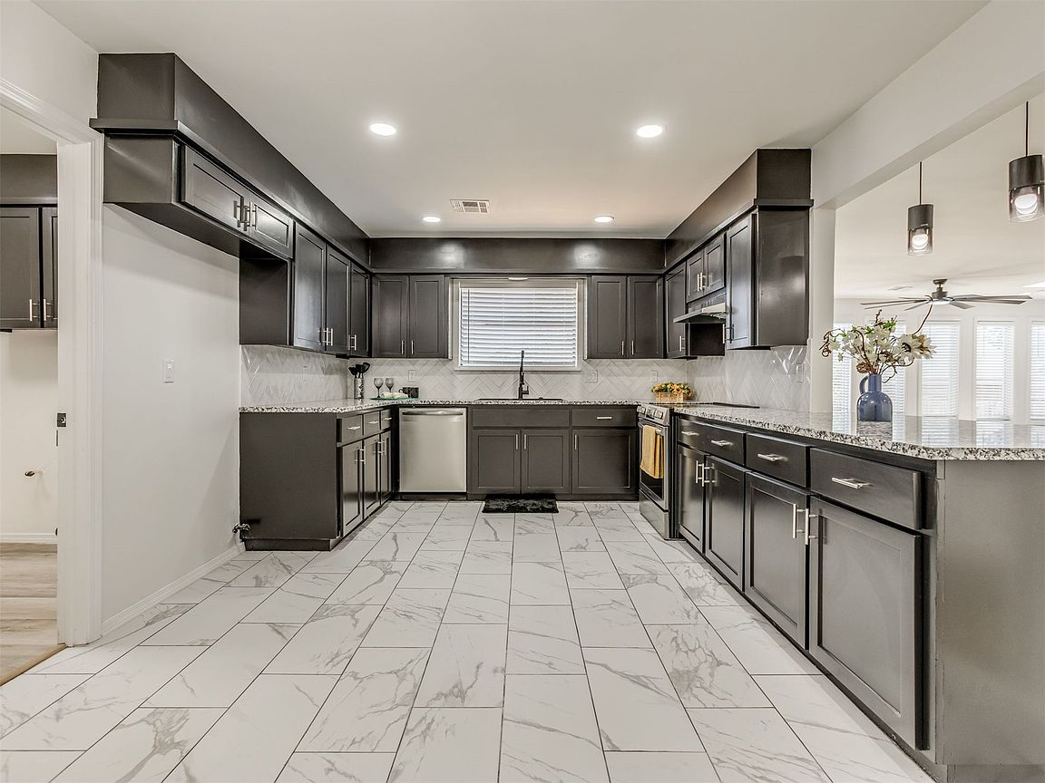 Updated kitchen with dark cabinetry and stainless appliances