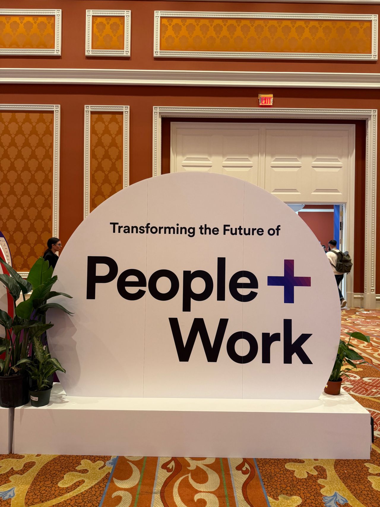 Large conference sign reading "Transforming the Future of People + Work"