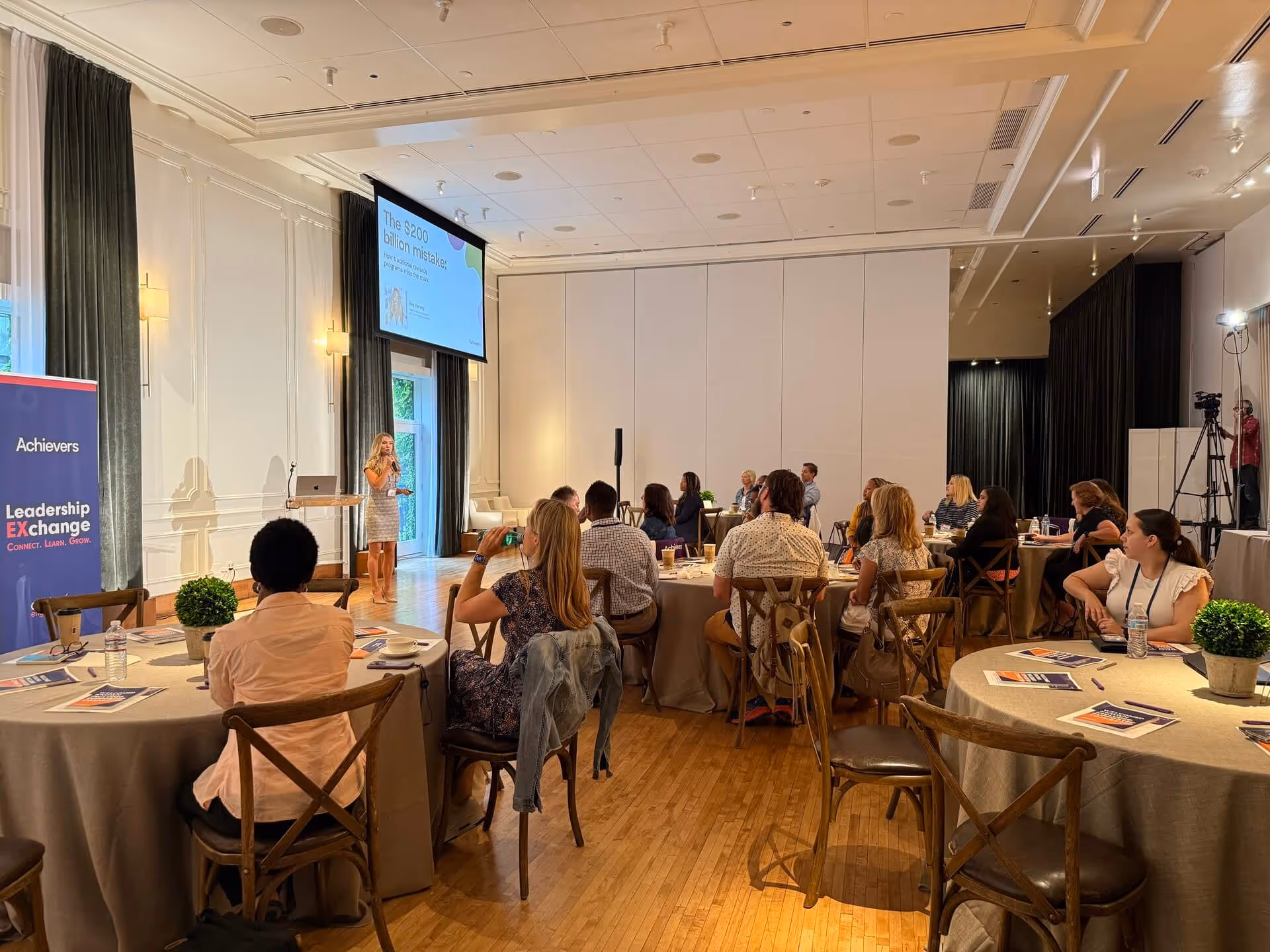 Achievers Leadership Exchange conference with speaker and audience in professional setting