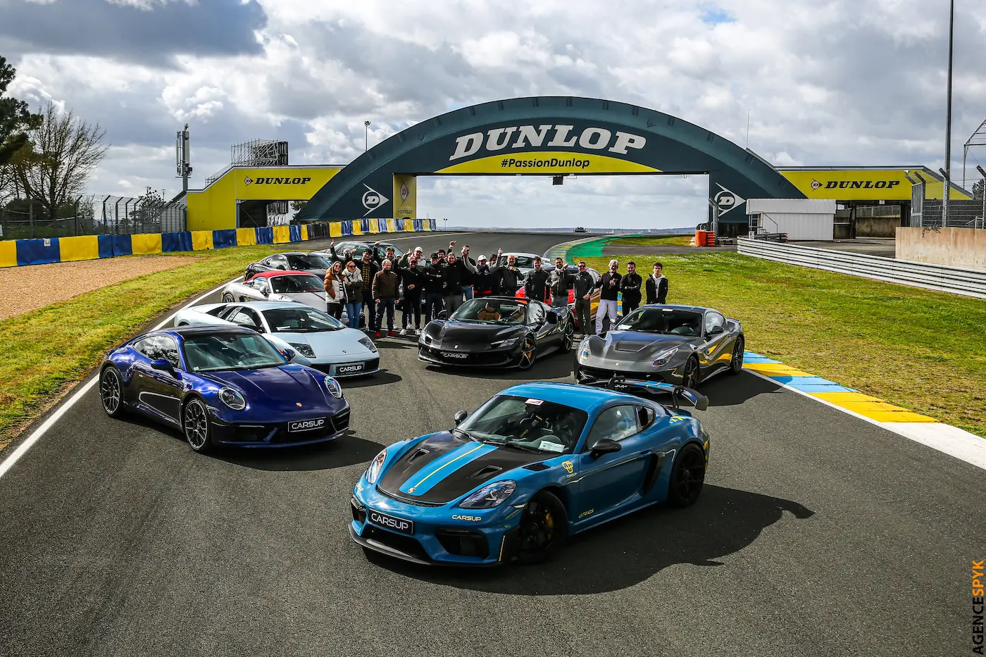 Groupe de passionnés automobiles et voitures sportives Carsup rassemblés sur le circuit Dunlop lors d'un événement exclusif.