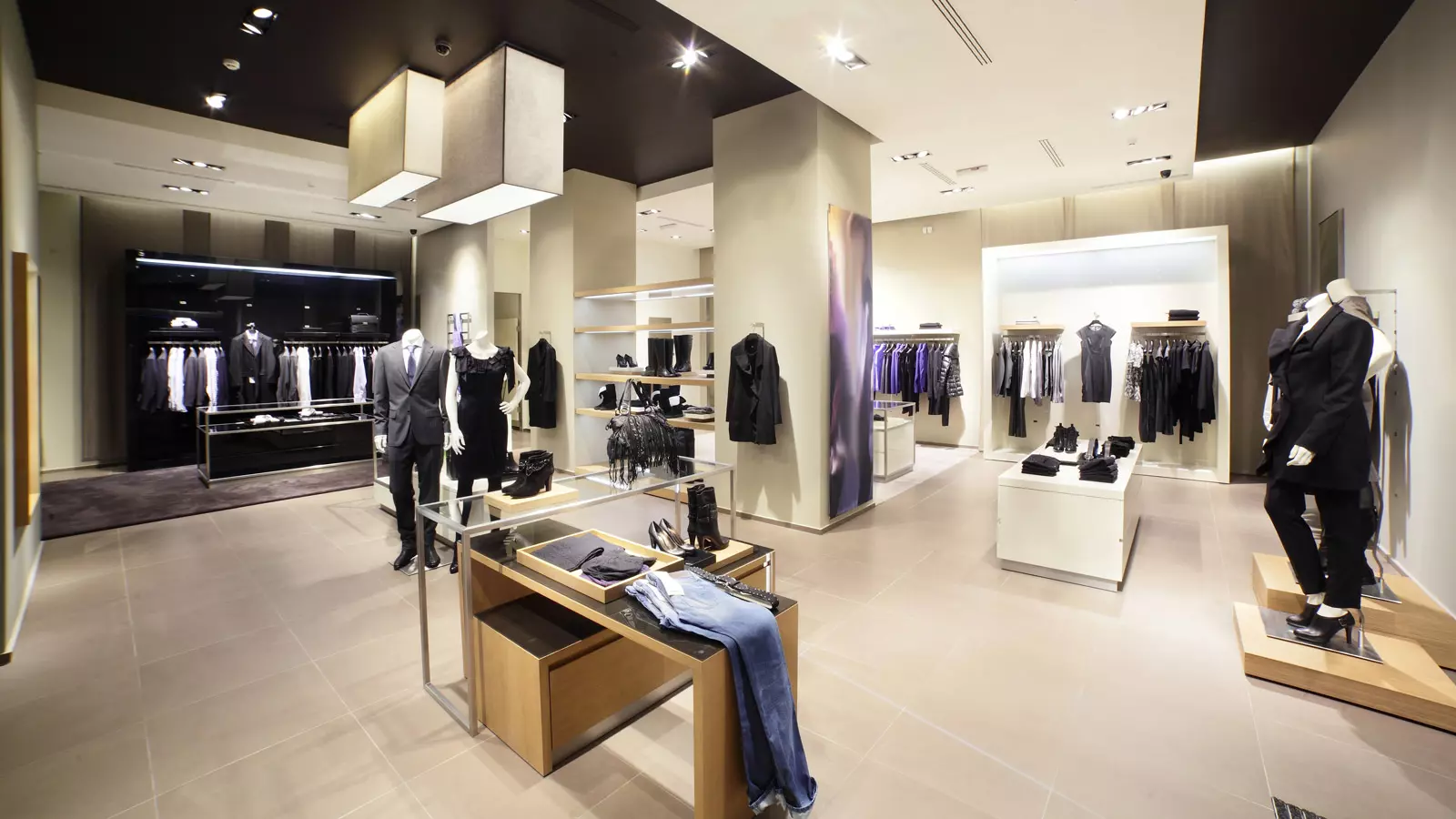 고급 의류 매장에 마네킹과 다양한 패션 아이템이 진열된 모습. 고객 만족도를 높이기 위한 효율적인 품절관리 및 매장 재고 운영 현장