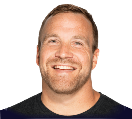 Smiling man with light brown hair and beard wearing a dark shirt.