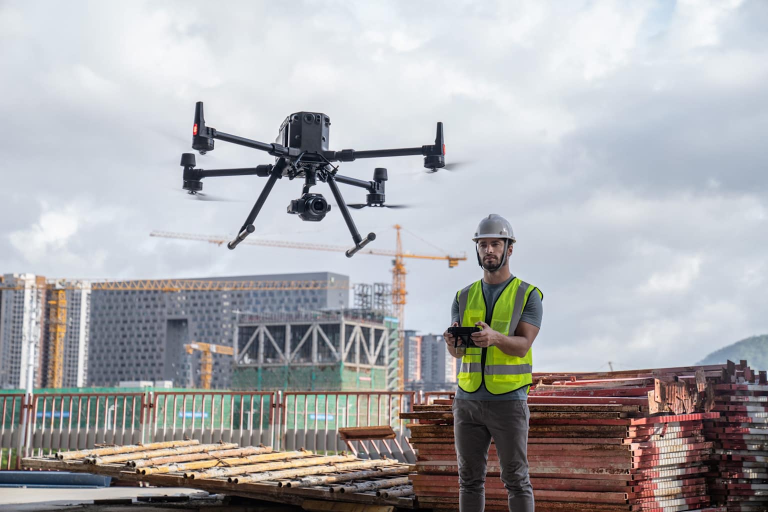 A professional drone operator conducts an inspection at a construction site using a commercial-grade drone