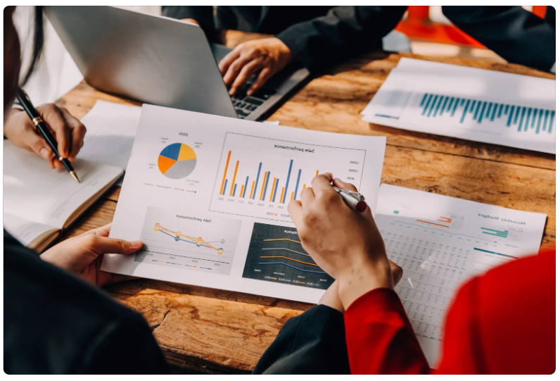 Business team reviewing financial and performance reports together, illustrating beginner-friendly Snowflake use cases where centralized data enables faster, more consistent analytics across teams. i-radius
