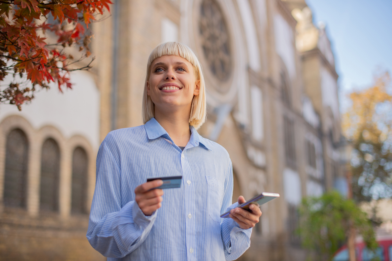 A woman is coming out of a church using her credit card