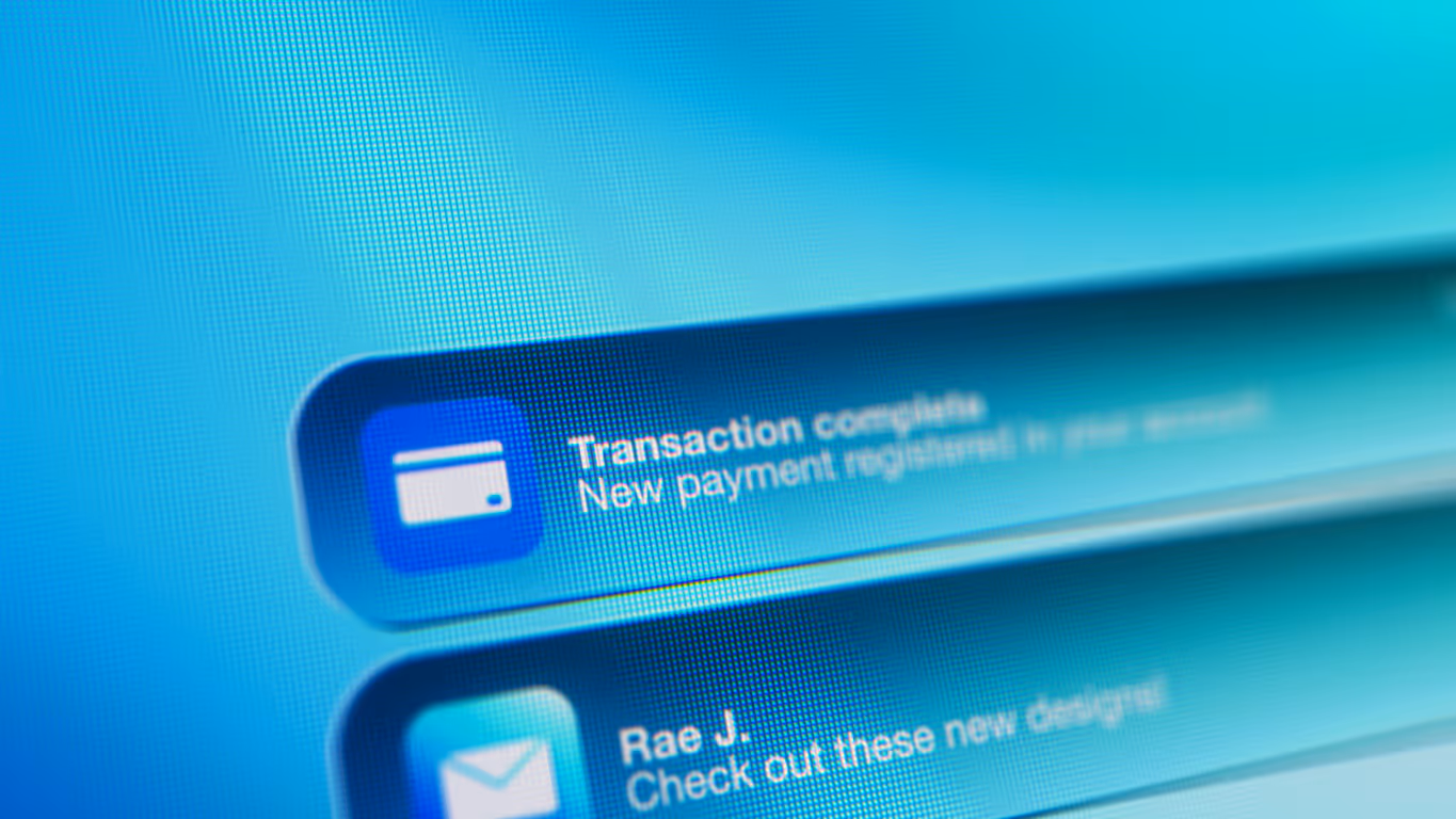 Close-up of a computer screen displaying a notification stating 'Transaction complete, New payment registered in your account'.
