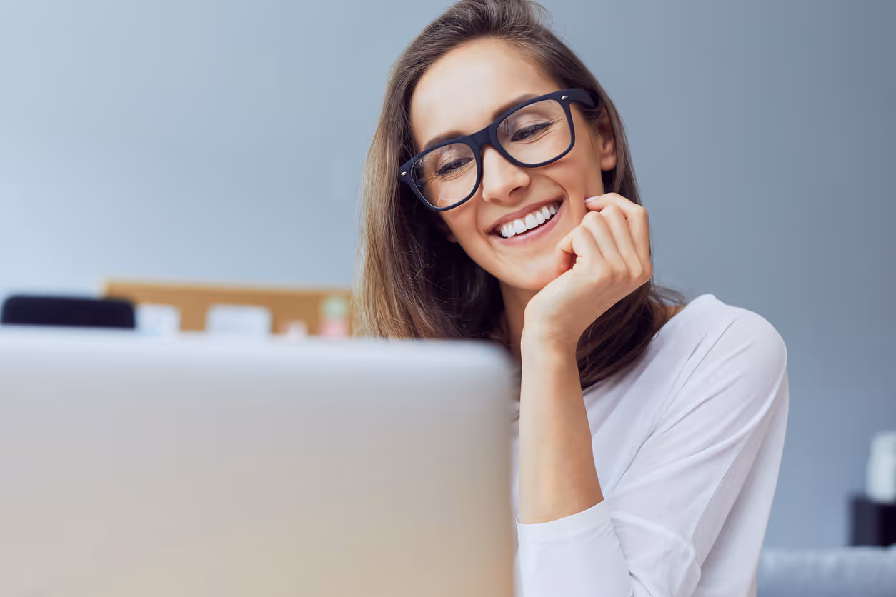 Person holding credit card in front of a laptop with digital security shield and technology icons overlay.
