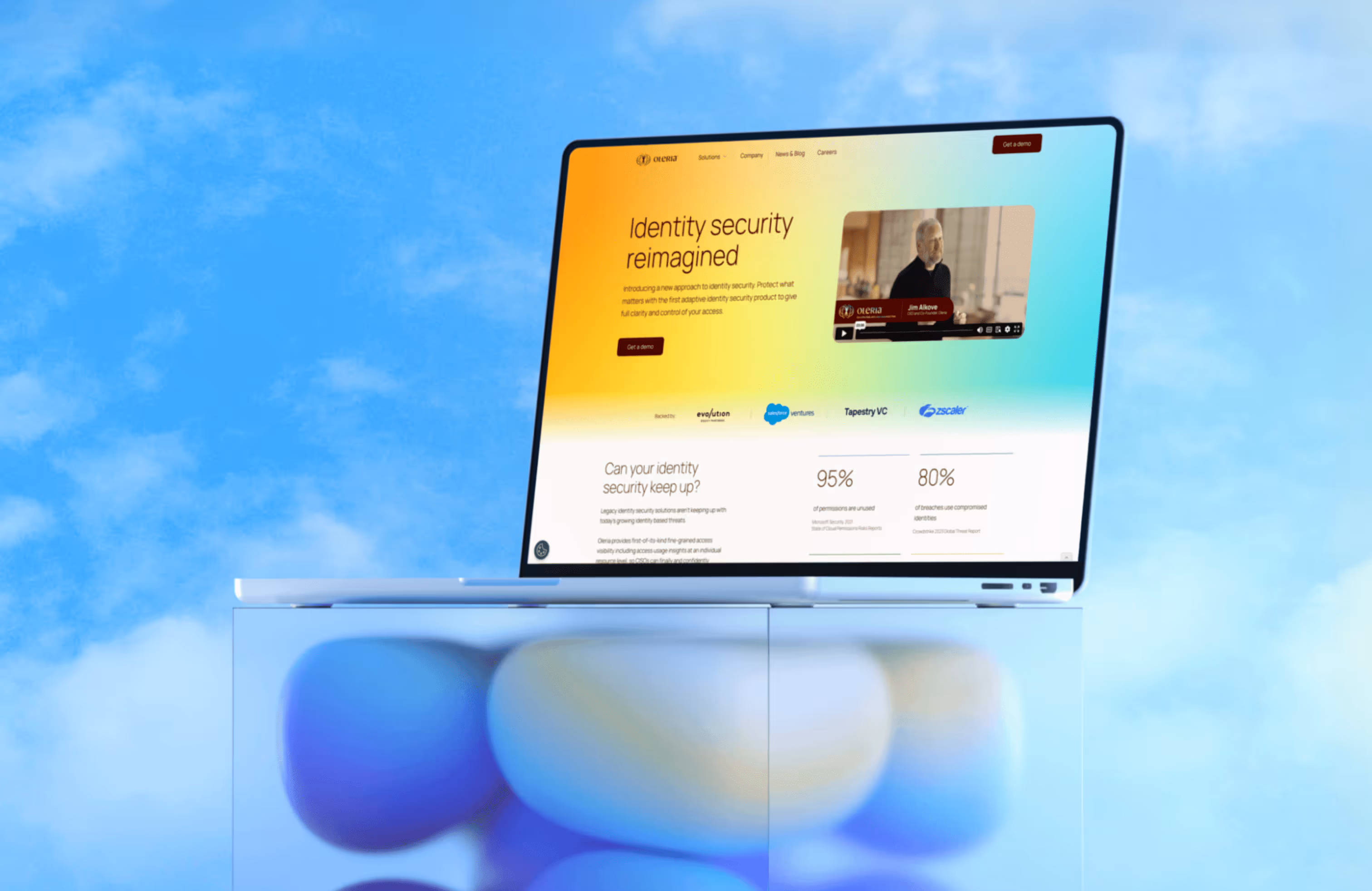 MacBook displaying Oleria cybersecurity website on glass surface with blue sky background. 