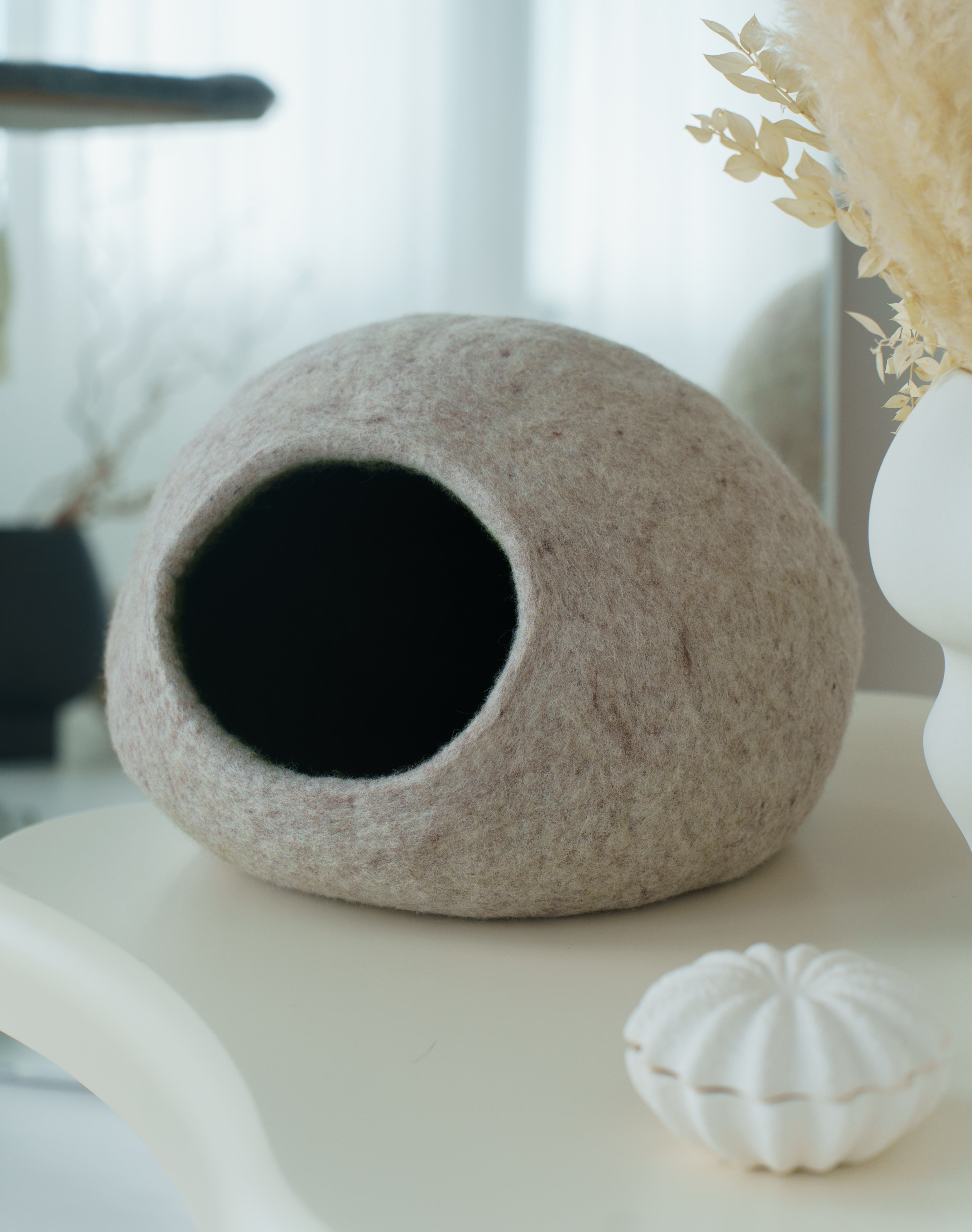 Felted wool Kikska caves in grey and cream on a soft rug