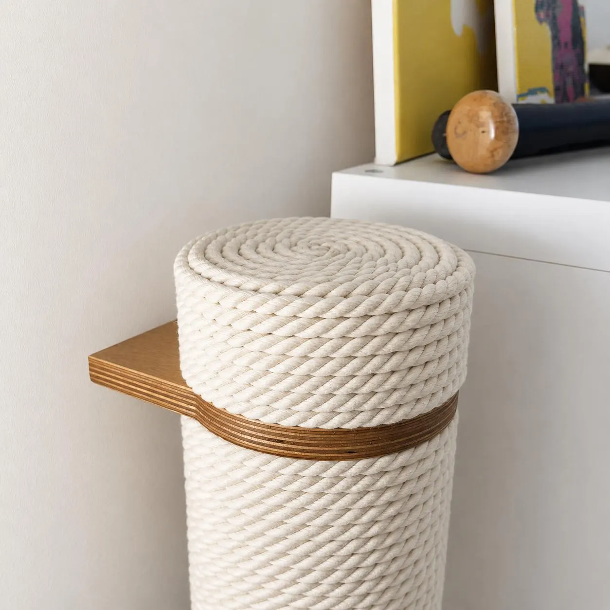 A cat climbing a wall-mounted Kikska scratching post