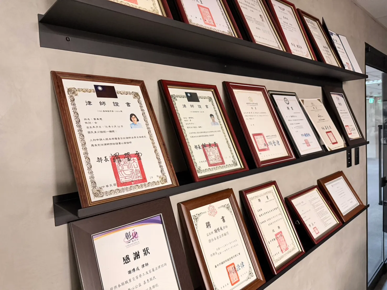 言衡國際法律事務所證照牆:展示律師團隊豐富的執業資歷、專業認證與客戶感謝狀。