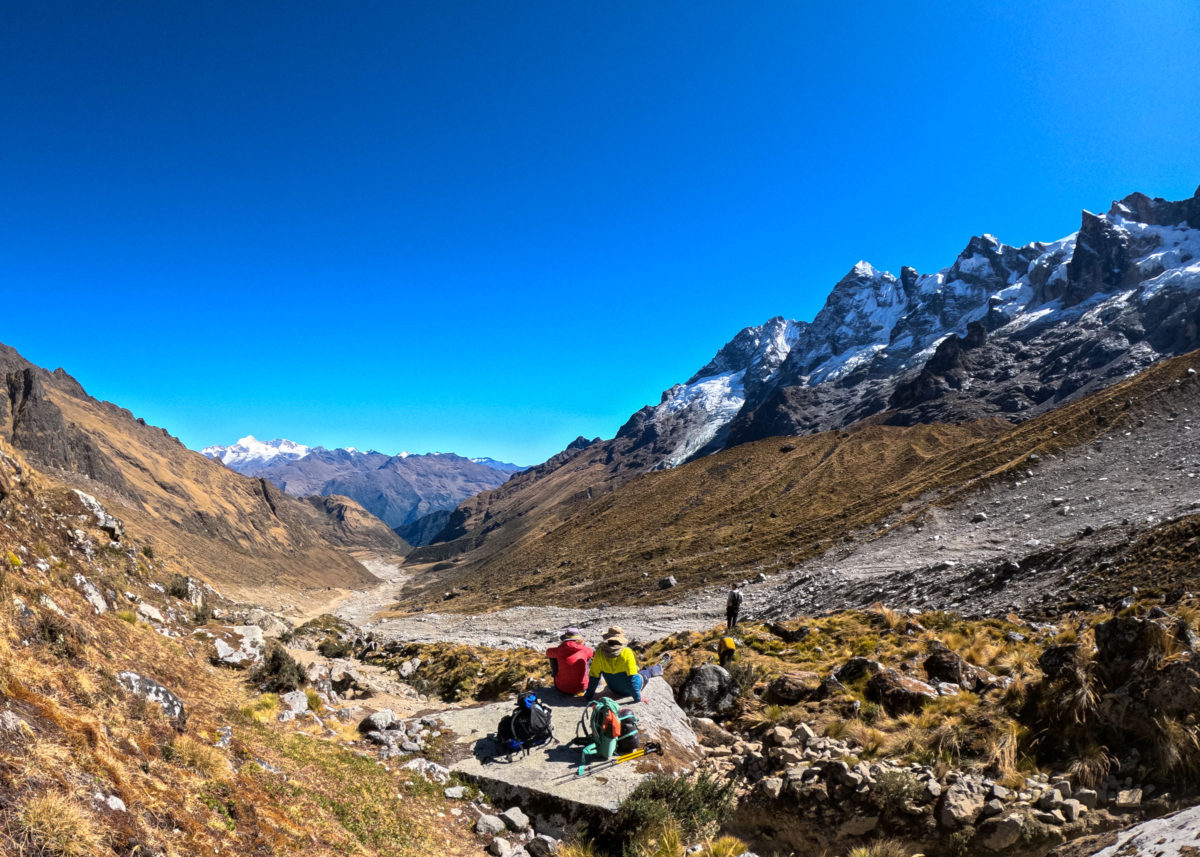 Randonneurs en pause dans la descente du col de Salkantay, face aux sommets enneigés