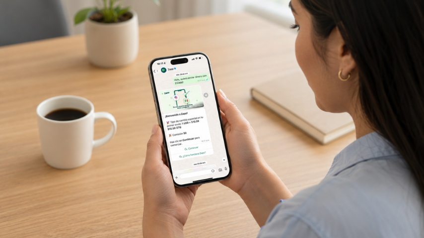 Persona usando una app de envío de dinero en su celular, con una conversación de Zapp en WhatsApp sobre transferencias internacionales desde Estados Unidos a Guatemala.