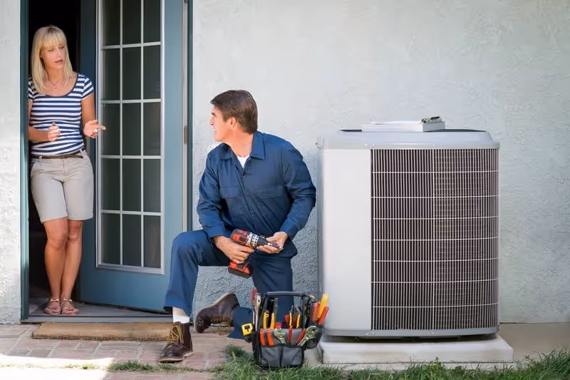 HVAC technician talks to female homeowner.