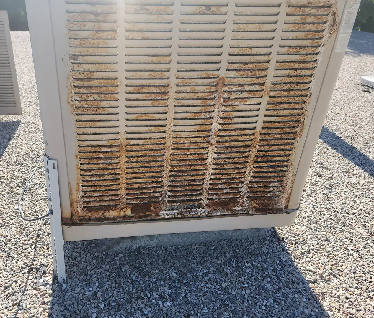 An aging, rusted air conditioning unit with bent fins and debris buildup - ac installation in cottonwood heights ut