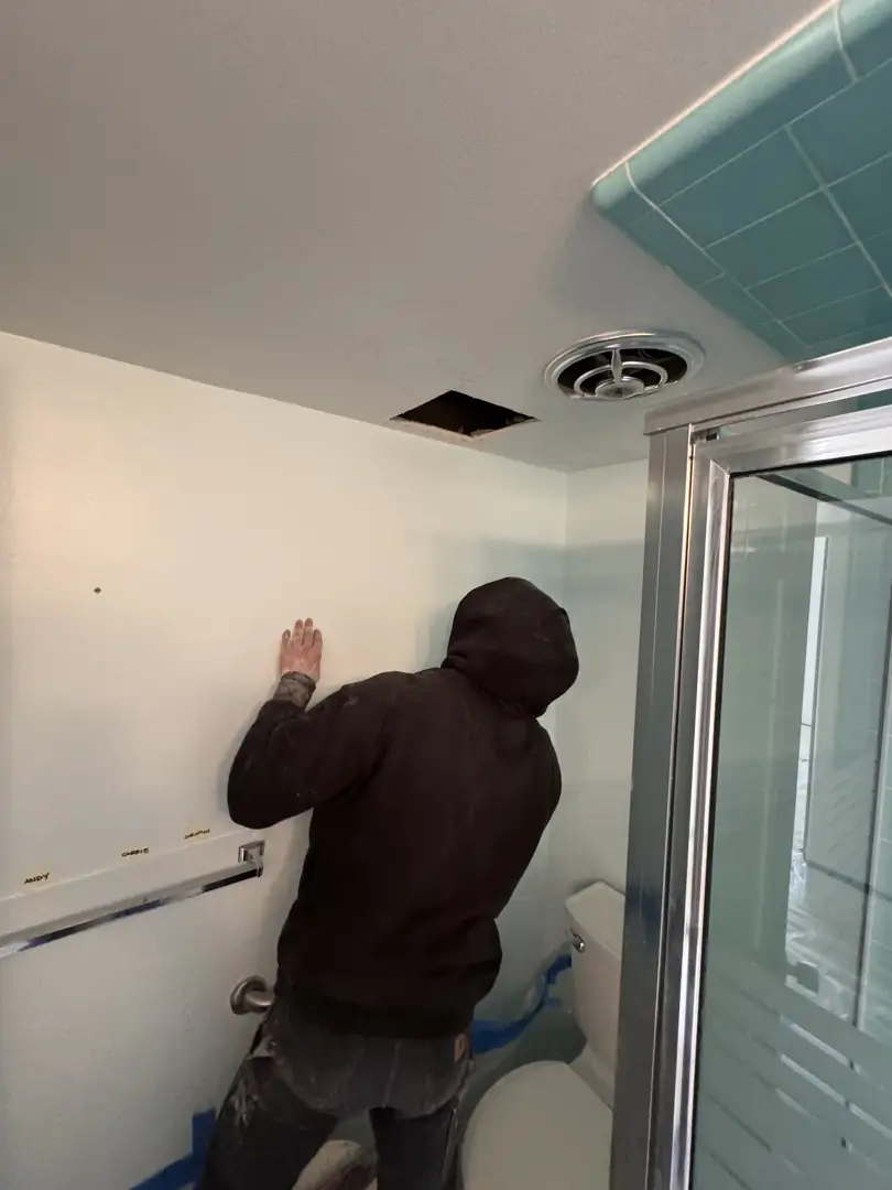 Licensed plumber installing a modern thermostatic shower valve behind a bathroom wall - bathroom remodeling plumbing Licensed plumber installing a modern thermostatic shower valve behind a bathroom wall - bathroom remodeling plumbing