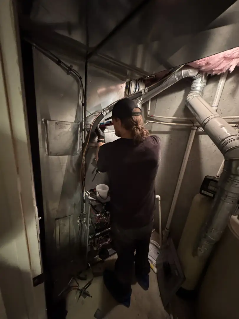 A technician pointing to a refrigerant detection system sensor inside a modern AC unit - how ac refrigerant changes affect A technician pointing to a refrigerant detection system sensor inside a modern AC unit - how ac refrigerant changes affect