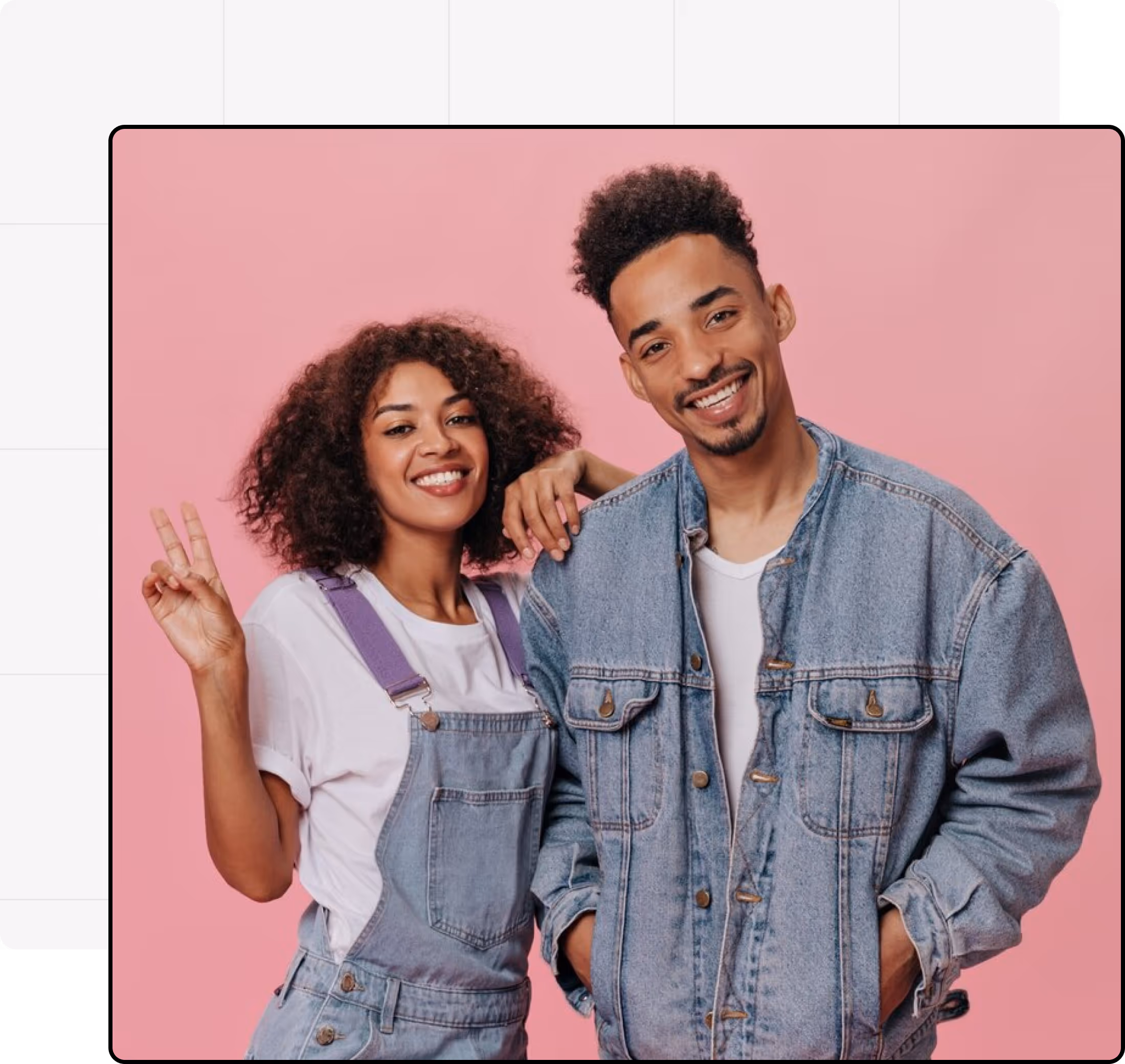 Smiling young woman showing a peace sign and standing beside a smiling man in denim jackets, both posing against a pink background.