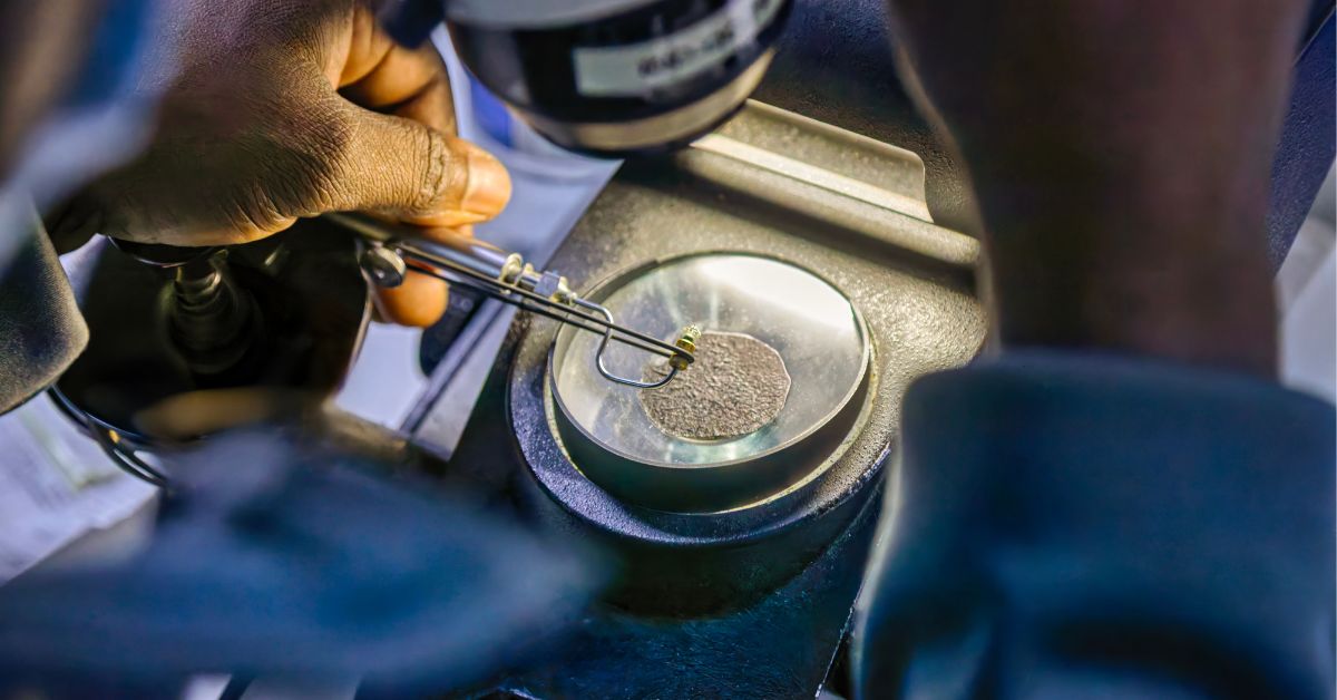 Professional reviewing a precious metal item under a microscope as part of the evaluation process at Paradigm Experts.