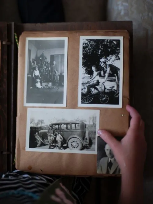 Old black and white photographs in an album showing a couple with their family