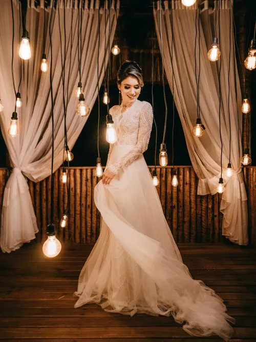 A beautiful Arabic bride posing for a photograph in her wedding dress by a window