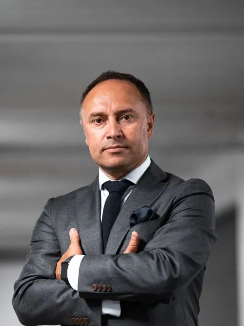 Portrait of a serious looking businessman standing with his arms folded looking into camera
