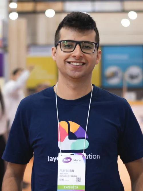 A trade show exhibitor wear their badge standing in front of a video camera smiling