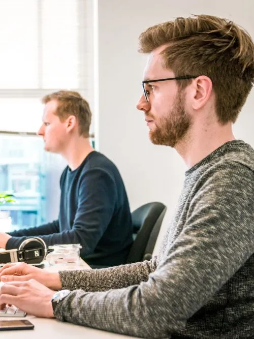 A freelance video editor sitting at a desk working on an Apple computer editing a video