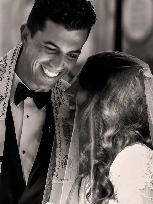 A Jewish bride and groom exchanges vows under a Chuppah during their wedding ceremony