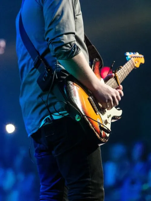 Filming from the back of a solo guitarist on stage at a live stage event