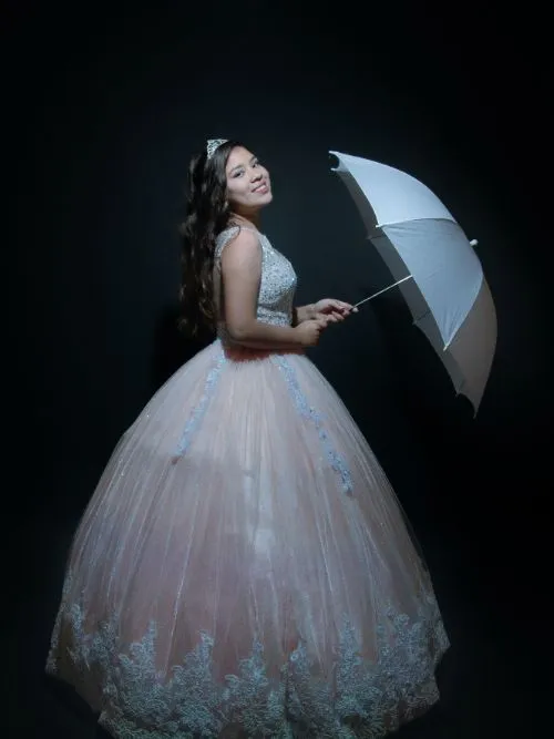 Photograph of a young school student wearing a prom dress with a white umbrella