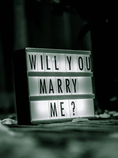 An illuminated sign saying 'Will You Marry Me' used for filming a marriage proposal