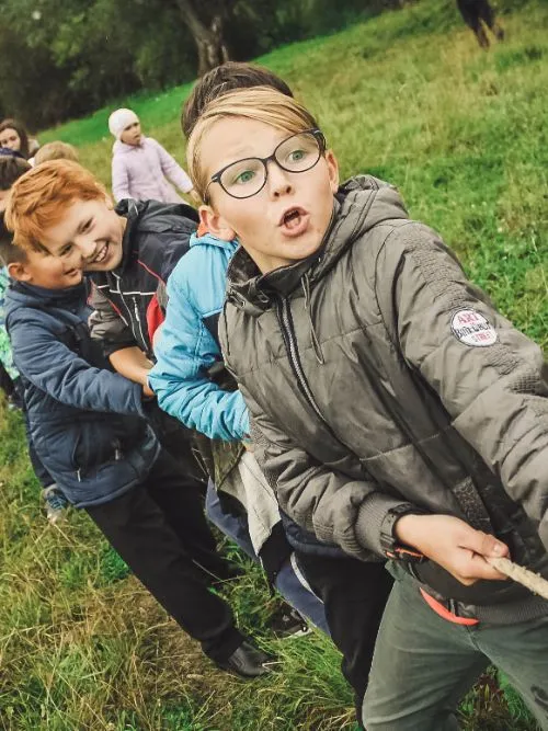 Photograph of a group of schoolchildren playing tug of war at a school event