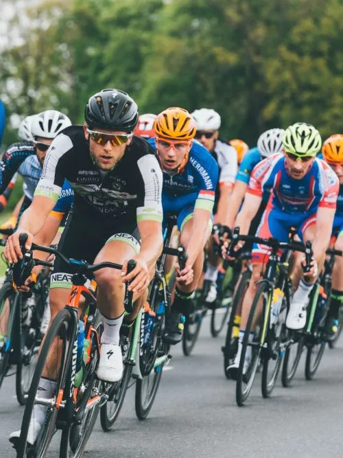 A group of competitive cyclists being filmed in the Prudential London Ride