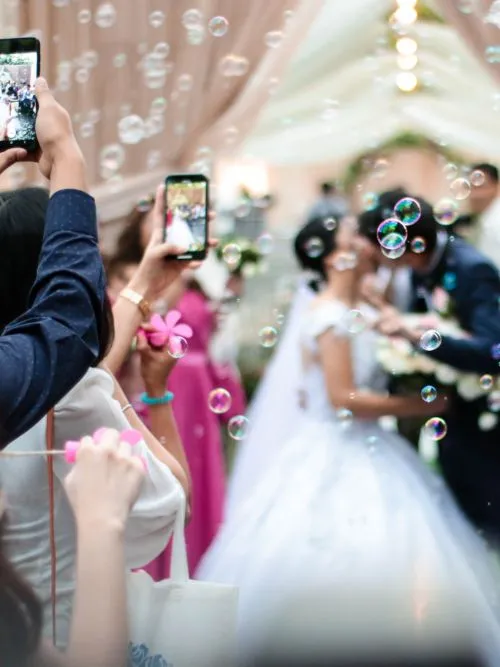 Editing of a wedding couple outside a church kissing with bubbles in the foreground