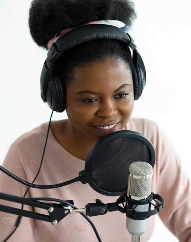 Black female voice artist in a studio recording with a microphone