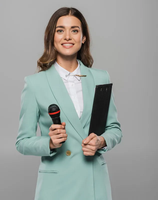 Young attractive woman in a light green suit holding an interview microphone