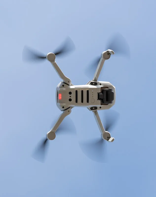 Underside view of a drone made by DJI flying through the air